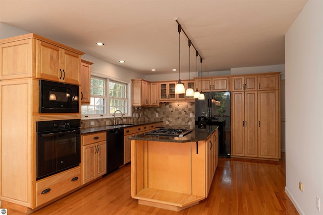 kitchen featuring black appliances, a sink, decorative backsplash, light brown cabinets, and recessed lighting