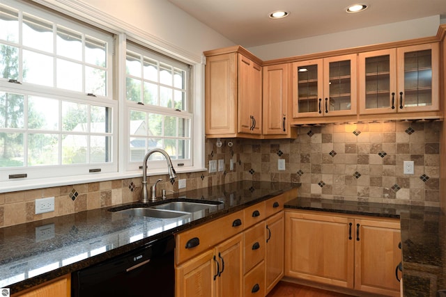 kitchen featuring black dishwasher, a sink, glass insert cabinets, decorative backsplash, and recessed lighting