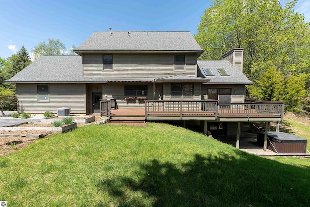 back of house with a hot tub, a deck, cooling unit, and a chimney