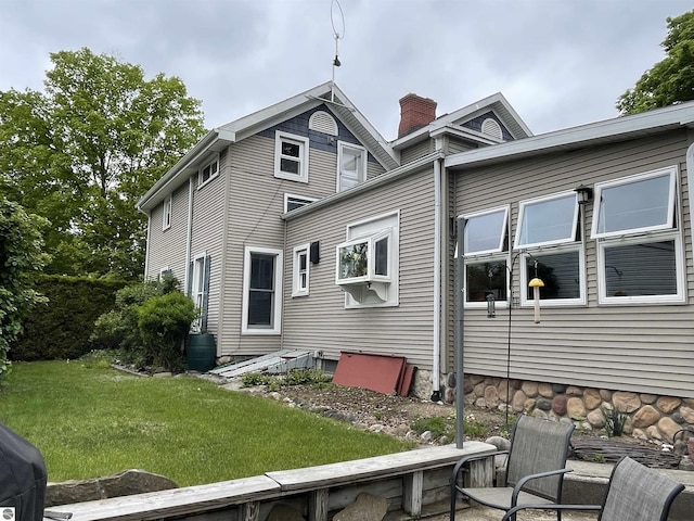 630 N State St, Alma, MI 48801 - view of side of home featuring a chimney and a yard