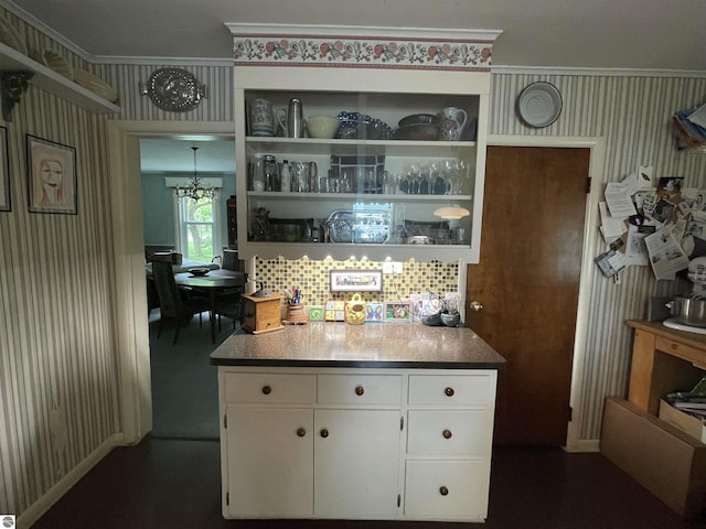 630 N State St, Alma, MI 48801 - kitchen with a chandelier, wallpapered walls, white cabinetry, and crown molding