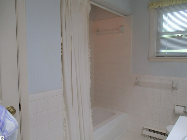 8481 N Luce Rd, Alma, MI 48801 - full bath featuring tile walls, a baseboard heating unit, wainscoting, shower / bathtub combination with curtain, and toilet