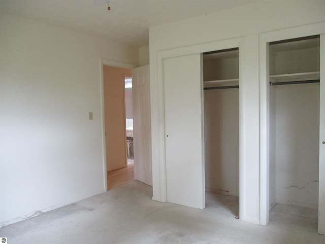8481 N Luce Rd, Alma, MI 48801 - unfurnished bedroom featuring light colored carpet and two closets