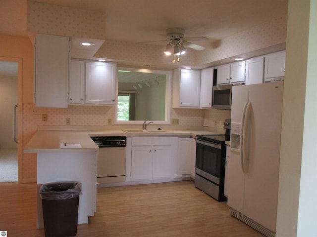 8481 N Luce Rd, Alma, MI 48801 - kitchen featuring stainless steel appliances, a sink, light wood finished floors, and white cabinetry