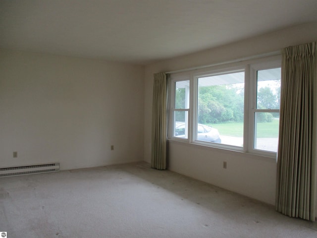8481 N Luce Rd, Alma, MI 48801 - empty room featuring baseboard heating, plenty of natural light, and light carpet
