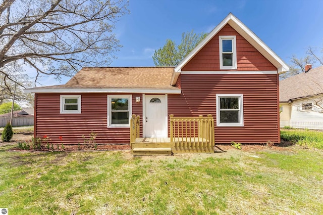 968 Barlow St, Traverse City, MI 49686 - view of front of home featuring a front yard, roof with shingles, and a deck