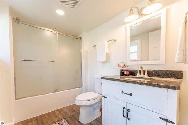 968 Barlow St, Traverse City, MI 49686 - full bathroom with wood finished floors, toilet, vanity, combined bath / shower with glass door, and recessed lighting