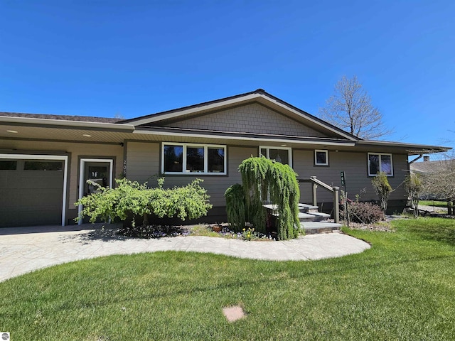 205 S Elm St, Suttons Bay, MI 49682 - view of front of house with an attached garage, a front yard, and concrete driveway
