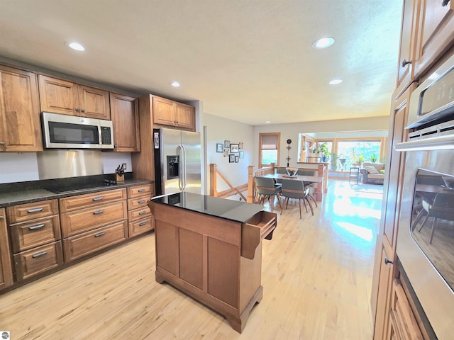 205 S Elm St, Suttons Bay, MI 49682 - kitchen with appliances with stainless steel finishes, dark countertops, light wood-type flooring, recessed lighting, and brown cabinets