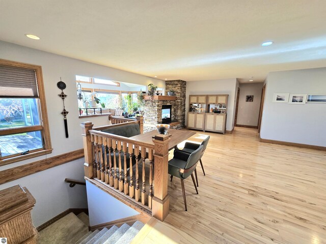205 S Elm St, Suttons Bay, MI 49682 - dining space featuring a stone fireplace, baseboards, light wood-style flooring, and recessed lighting