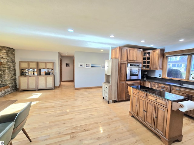 205 S Elm St, Suttons Bay, MI 49682 - kitchen featuring oven, light wood-type flooring, dark countertops, recessed lighting, and brown cabinets