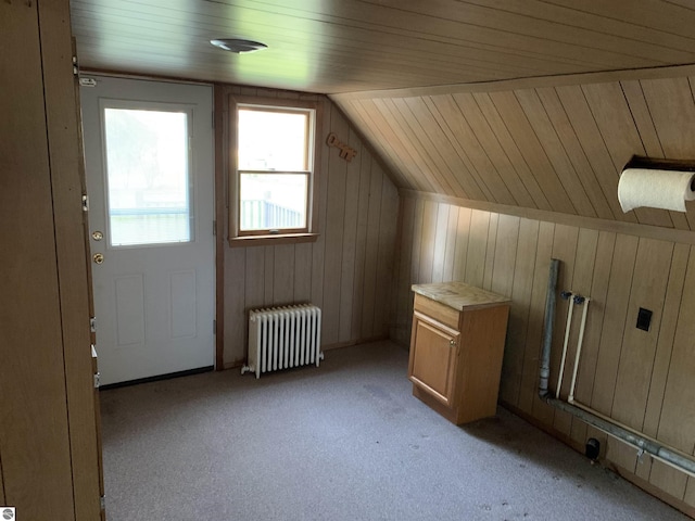 bonus room with radiator, lofted ceiling, wooden walls, light colored carpet, and wood ceiling