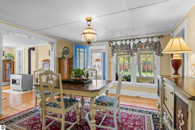 302 N Rose St, Northport, MI 49670 - dining area with light wood-style flooring, a chandelier, baseboards, and ornamental molding