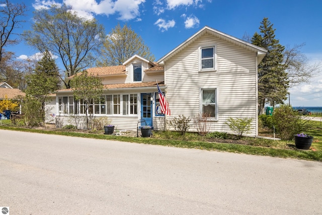 302 N Rose St, Northport, MI 49670 - traditional-style home with a sunroom and a shingled roof