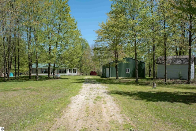 2250 N Coleman Rd, Coleman, MI 48618 - view of green lawn featuring dirt driveway, an outdoor structure, and a pole building