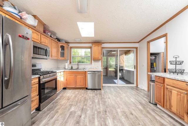 2250 N Coleman Rd, Coleman, MI 48618 - kitchen with appliances with stainless steel finishes, a sink, ornamental molding, a skylight, and light wood finished floors