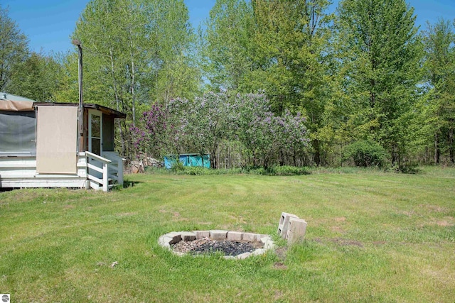 2250 N Coleman Rd, Coleman, MI 48618 - view of grassy yard with a fire pit and an outdoor structure