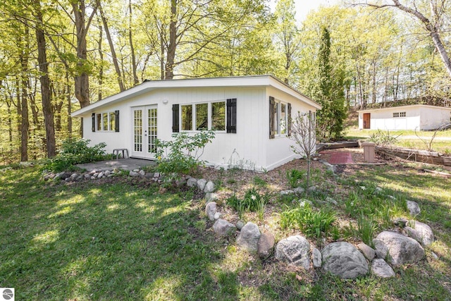 11199 Center Rd, Traverse City, MI 49686 - view of side of home with french doors, a yard, and a patio