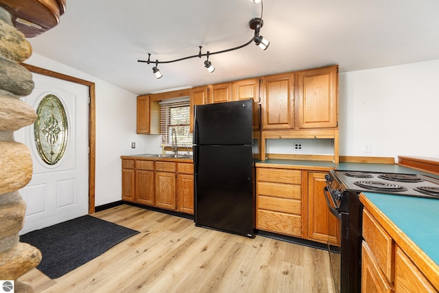 11199 Center Rd, Traverse City, MI 49686 - kitchen with black appliances, a sink, light wood-type flooring, and rail lighting