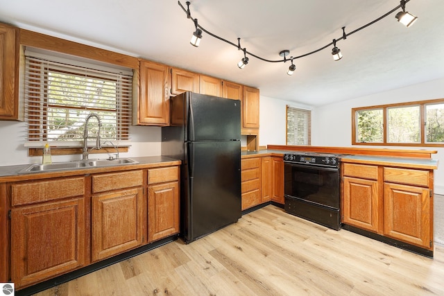 11199 Center Rd, Traverse City, MI 49686 - kitchen with freestanding refrigerator, range with electric stovetop, a sink, light wood finished floors, and a peninsula