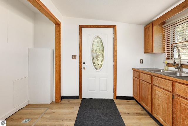 11199 Center Rd, Traverse City, MI 49686 - kitchen with a sink, light wood-style floors, and brown cabinetry
