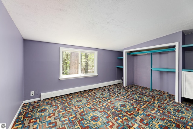 11199 Center Rd, Traverse City, MI 49686 - unfurnished bedroom featuring a baseboard heating unit, a textured ceiling, carpet floors, a closet, and baseboards