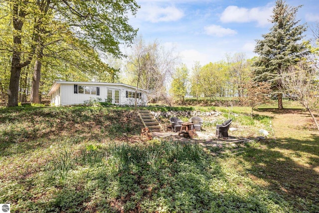 11199 Center Rd, Traverse City, MI 49686 - view of yard with french doors, a fire pit, and stairway