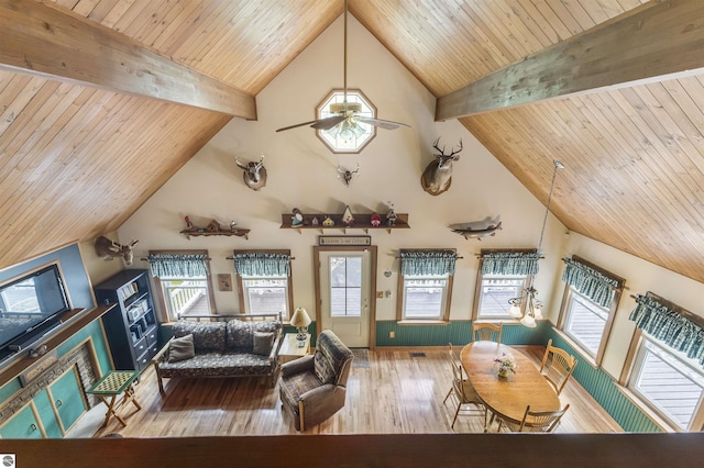 living room featuring hardwood / wood-style flooring, high vaulted ceiling, wood ceiling with exposed beams, healthy amount of natural light, and ceiling fan