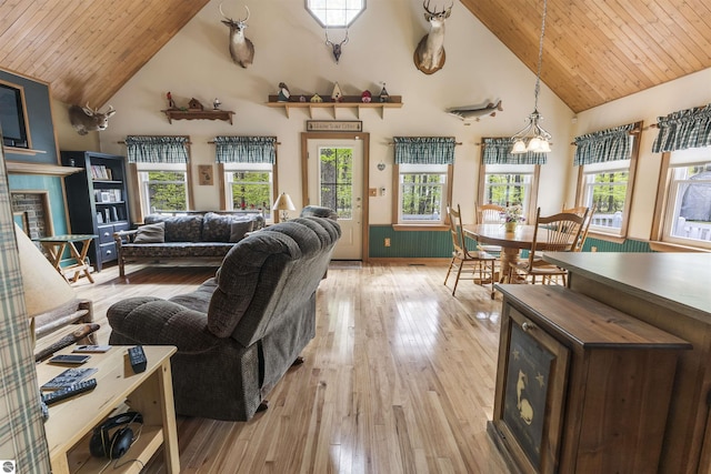 living area featuring high vaulted ceiling, light wood-style flooring, wood ceiling, and a chandelier
