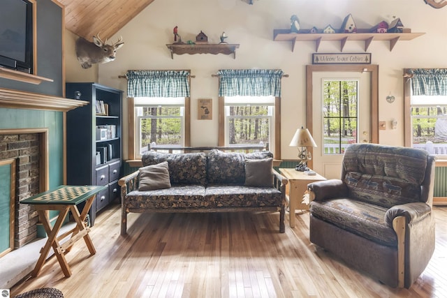 living room featuring light wood-style flooring, a fireplace, lofted ceiling, radiator heating unit, and wooden ceiling