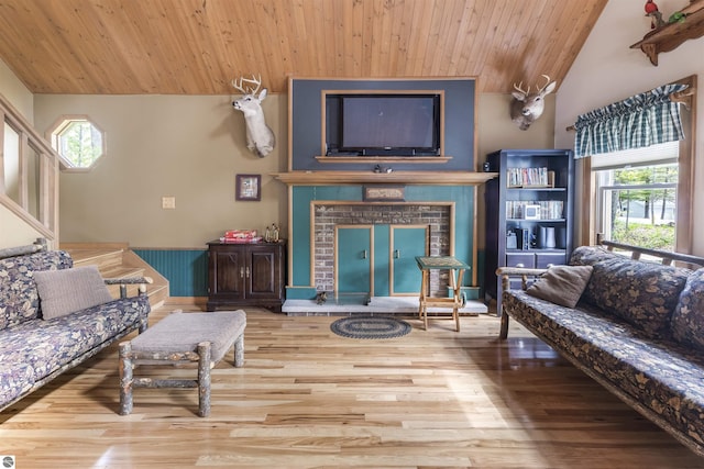 living area with wood ceiling, lofted ceiling, wood finished floors, and a fireplace
