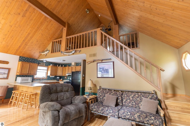 living room with high vaulted ceiling, wood ceiling with exposed beams, light wood-style floors, and stairs