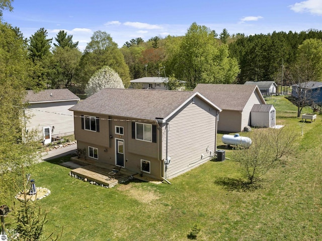 4267 Main St, Kingsley, MI 49649 - back of property featuring a deck, a yard, cooling unit, and a shingled roof