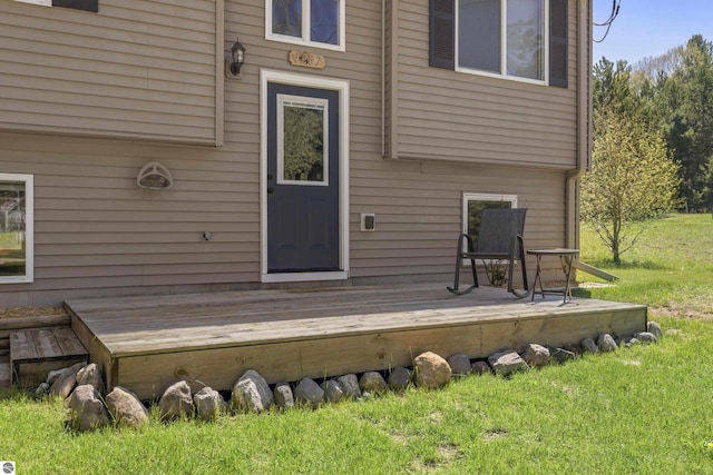4267 Main St, Kingsley, MI 49649 - rear view of property featuring a deck and a lawn