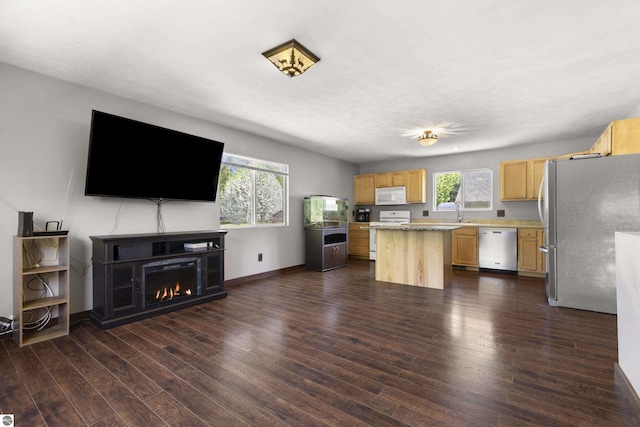 4267 Main St, Kingsley, MI 49649 - kitchen with stainless steel appliances, light brown cabinets, light countertops, a kitchen island, and dark wood-style floors