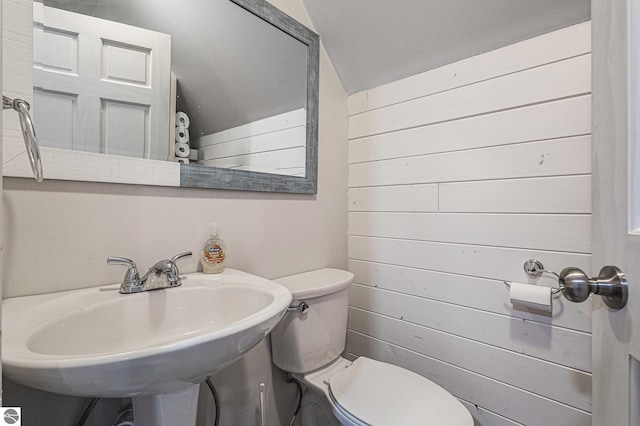 3290 Sumac Trl, Frankfort, MI 49635 - bathroom with wood walls, toilet, a sink, and lofted ceiling