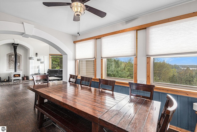 3290 Sumac Trl, Frankfort, MI 49635 - dining room featuring ceiling fan, a wood stove, arched walkways, and wood finished floors