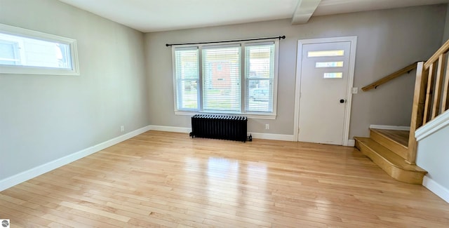 314 W Ninth St, Traverse City, MI 49684 - entrance foyer featuring radiator heating unit, light wood finished floors, plenty of natural light, and beam ceiling