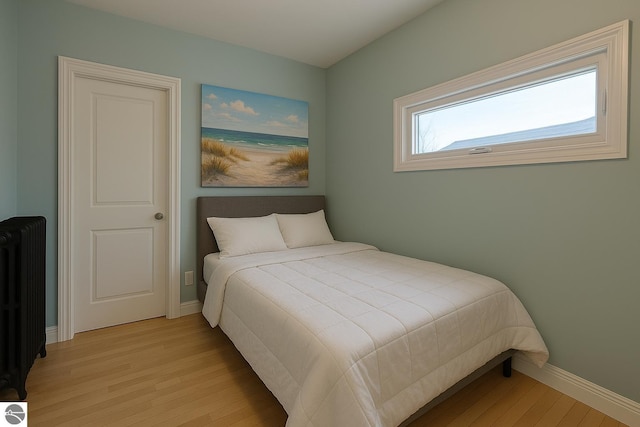 314 W Ninth St, Traverse City, MI 49684 - bedroom featuring radiator, light wood finished floors, and baseboards