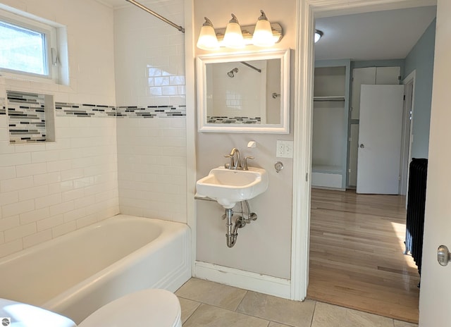 314 W Ninth St, Traverse City, MI 49684 - full bathroom with tile patterned floors, shower / bathtub combination, toilet, and radiator heating unit