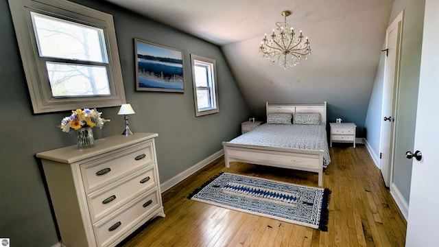 314 W Ninth St, Traverse City, MI 49684 - bedroom with a chandelier, baseboards, hardwood / wood-style floors, and vaulted ceiling