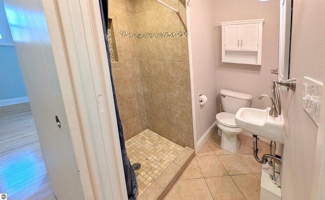 314 W Ninth St, Traverse City, MI 49684 - full bath with a stall shower, toilet, baseboards, tile patterned flooring, and a sink