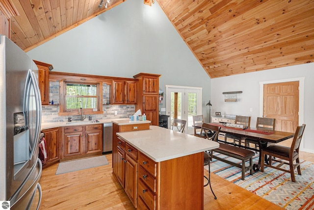 5301 Durga Rd, Williamsburg, MI 49690 - kitchen with appliances with stainless steel finishes, a breakfast bar, high vaulted ceiling, brown cabinets, and light wood-style floors
