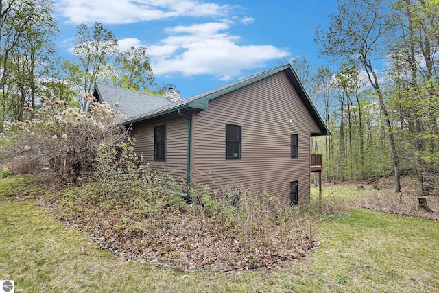 5301 Durga Rd, Williamsburg, MI 49690 - view of side of property featuring a chimney and a lawn