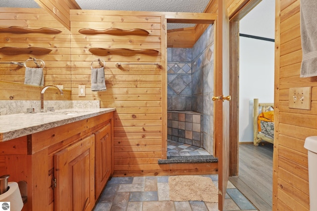 1493 NE Laura Ln, Kalkaska, MI 49646 - full bathroom with a shower stall, vanity, and wood walls