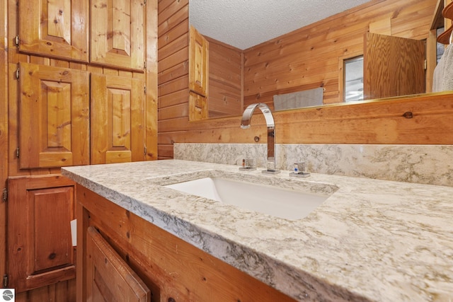 1493 NE Laura Ln, Kalkaska, MI 49646 - bathroom with a textured ceiling, vanity, and wood walls