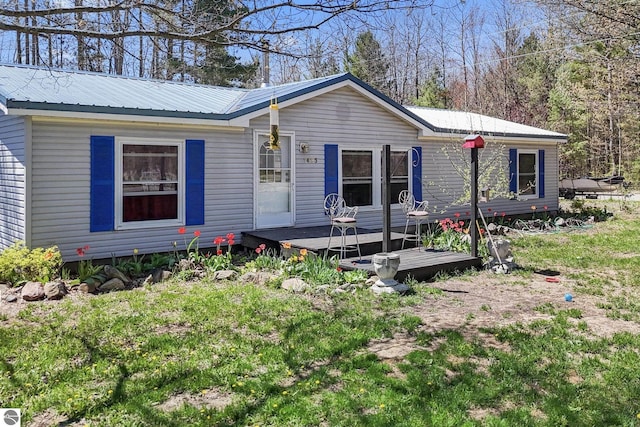 1493 NE Laura Ln, Kalkaska, MI 49646 - view of front facade with metal roof and a wooden deck