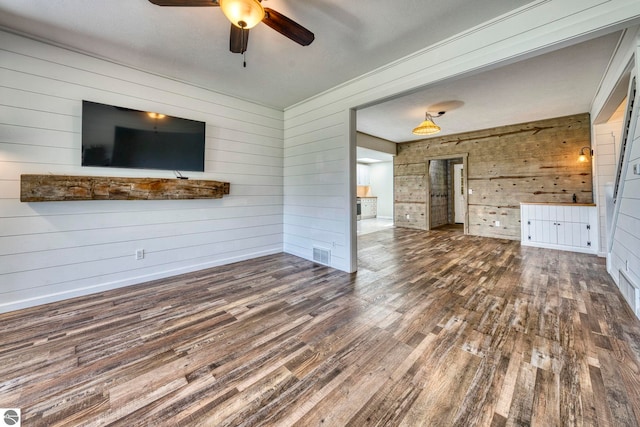 9560 S Cedar Rd, Cedar, MI 49621 - unfurnished living room featuring wood finished floors, wooden walls, and a ceiling fan