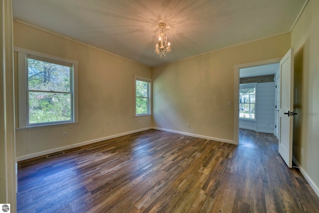 9560 S Cedar Rd, Cedar, MI 49621 - unfurnished room featuring a chandelier, dark wood-style floors, healthy amount of natural light, and ornamental molding
