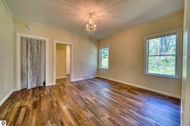 9560 S Cedar Rd, Cedar, MI 49621 - unfurnished bedroom with a chandelier, wood finished floors, ornamental molding, and baseboards